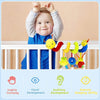 A smiling baby is holding a soft plush hanging toy, demonstrating sensory development skills.
