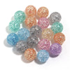 A collection of round loose spacer beads in various glitter colors including pink, green, silver, and gold tones.