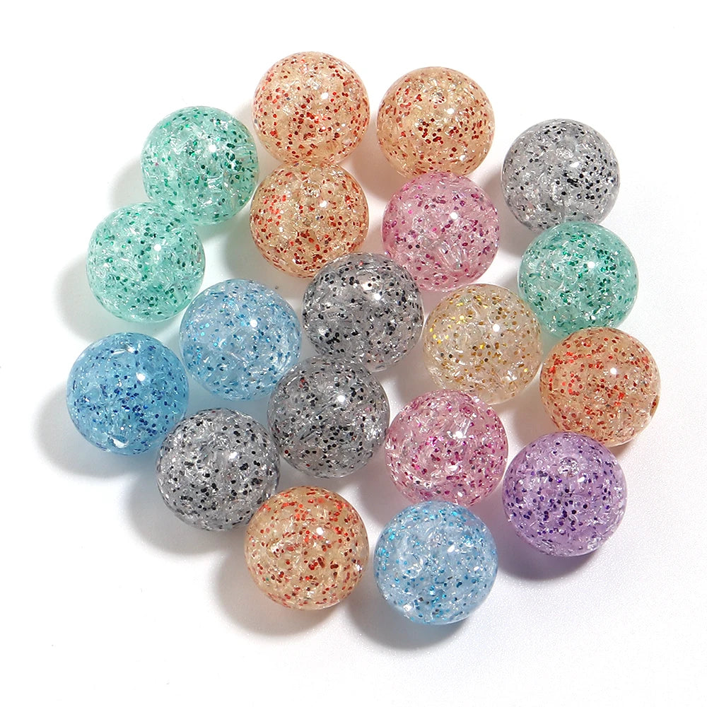 A collection of round loose spacer beads in various glitter colors including pink, green, silver, and gold tones.