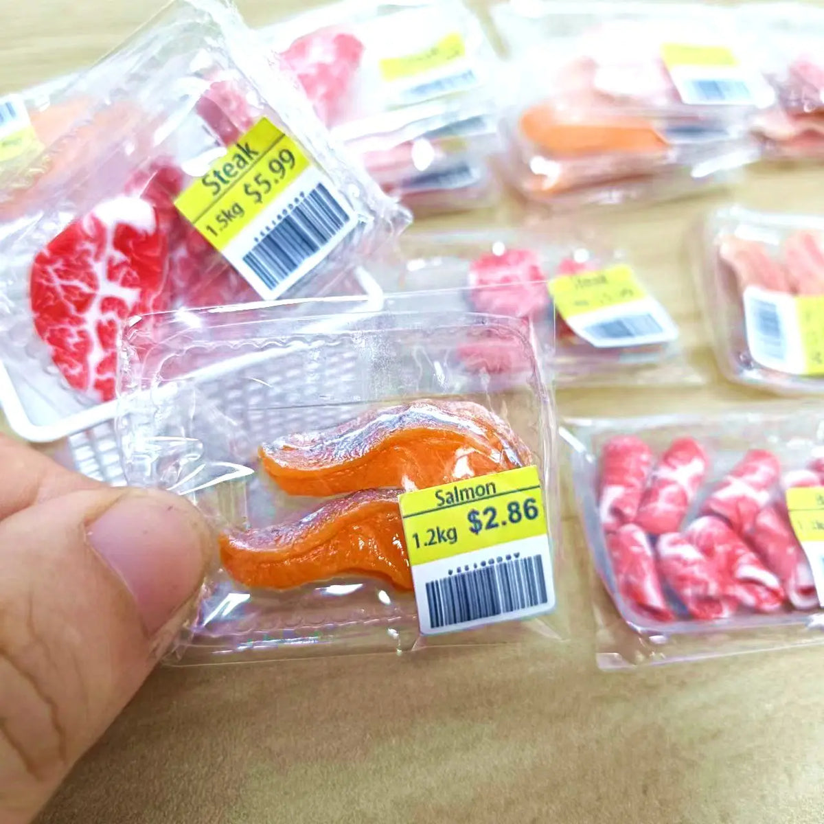 Packaged miniature dollhouse food set featuring realistic steak, salmon, and bacon rolls.