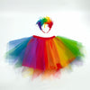 A colorful rainbow tulle tutu skirt and matching feather headband displayed against a white background.