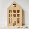A light wood building block shaped like a house with cut-out windows and a door.
