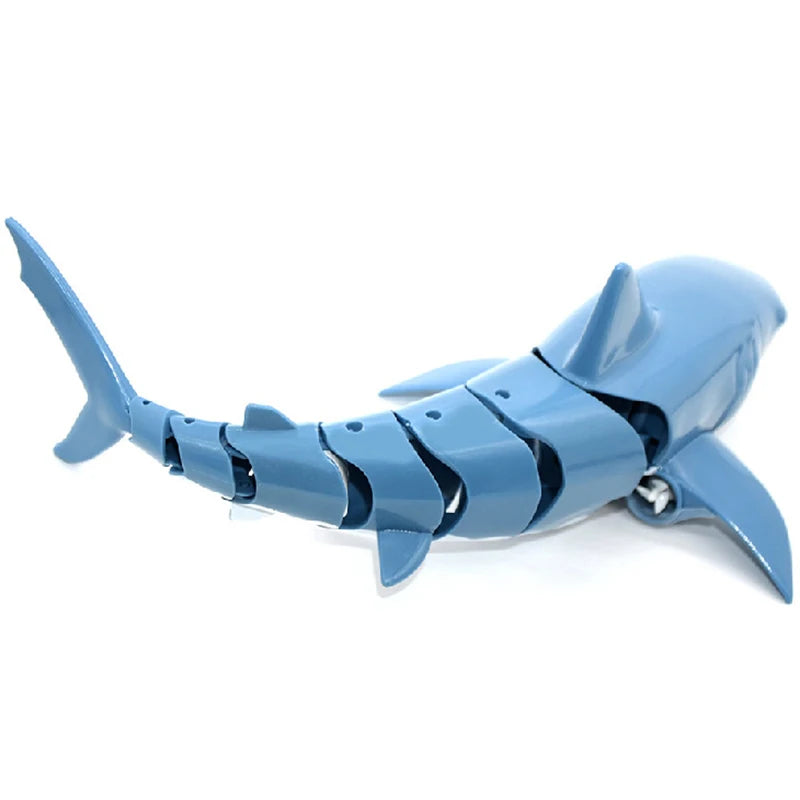 A blue remote control shark toy with a light and water spray feature.