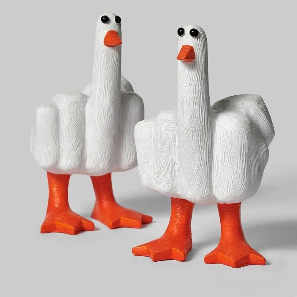 A white resin figurine of a goose with an orange beak and feet.