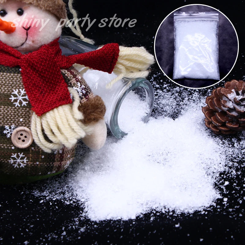 A close-up of artificial snow powder scattered on a dark surface next to a reindeer decoration and a pine cone.