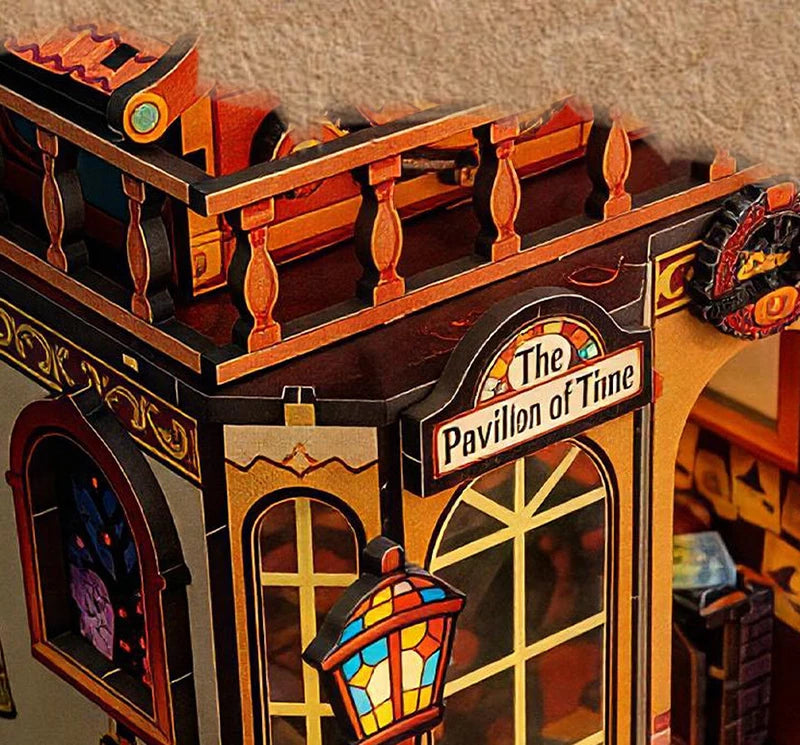 A miniature wooden dollhouse structure featuring an ornate pavilion with arched windows and decorative trim.