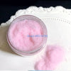A clear jar filled with pink adhesive flocking powder for jewelry making and crafts, resting on a white surface.
