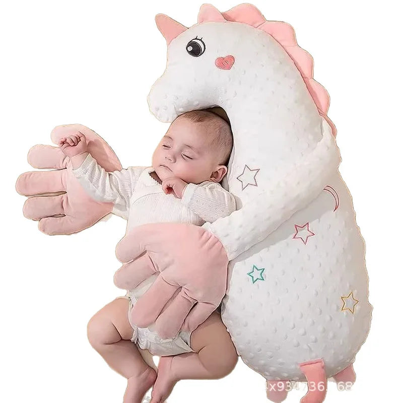 A white unicorn plush toy shaped like a baby with pink accents and soft textures.