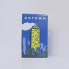 A blue box for the Gotown card game featuring a yellow skyscraper against a blue sky and clouds.