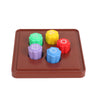 A set of five colored stones, including green, yellow, red, purple, and blue, arranged on a brown tray for a traditional Kore