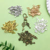 A collection of vintage brass and silver key charms and pendants for jewelry making displayed on a light green surface.