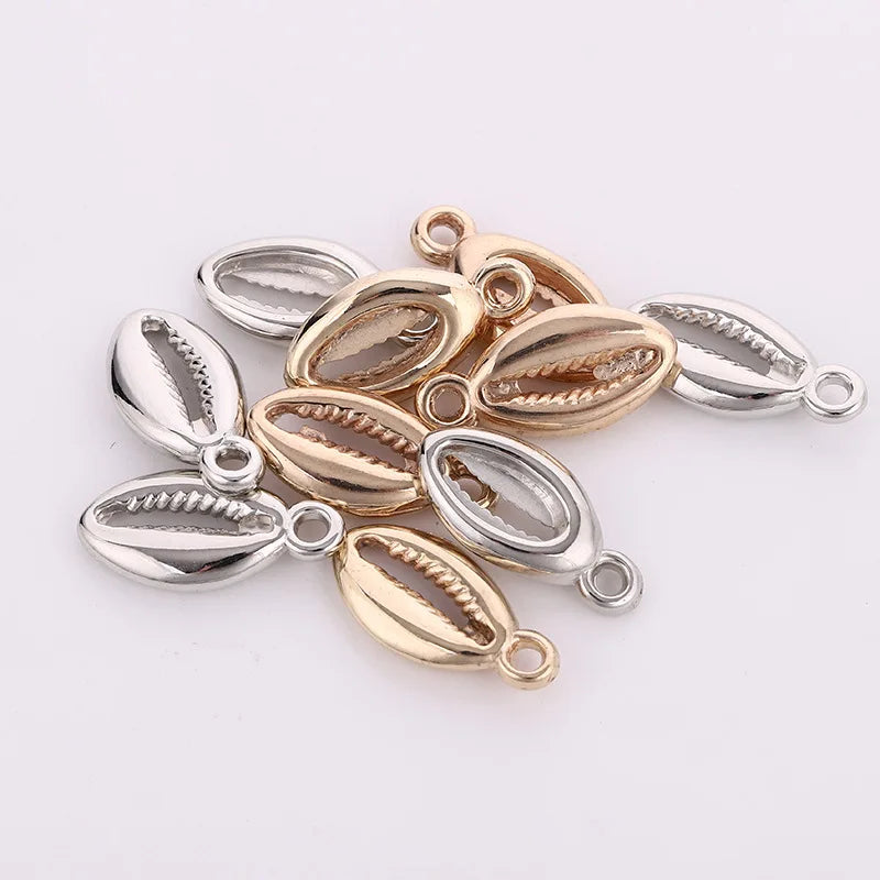 A collection of 50 plastic seashell charms in silver and gold finishes for jewelry making.