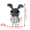 A gray plush doll resembling a small creature with large ears and a snout, shown against a measurement scale.