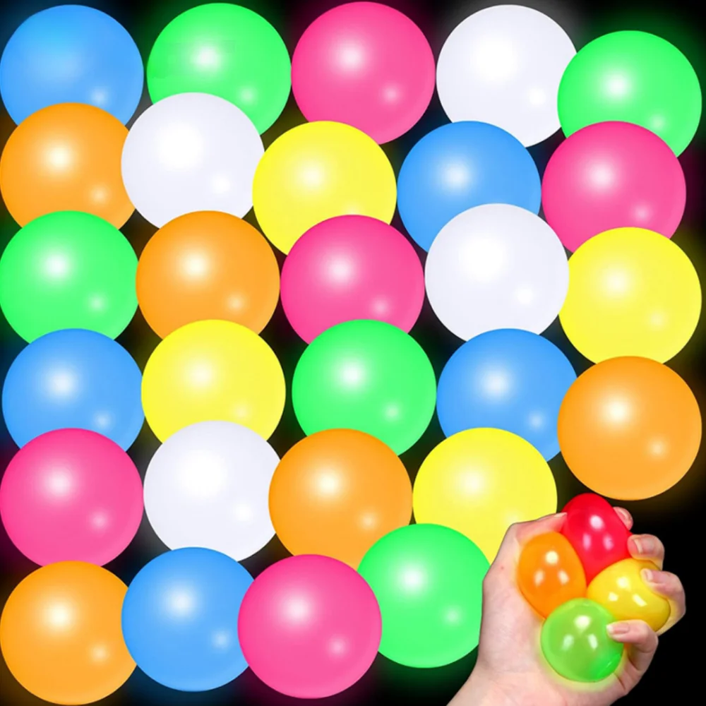 A hand is holding a collection of brightly colored squishy stress balls in various shades of pink, yellow, green, and blue.