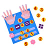 A blue felt board displaying various numbers and symbols, including fingers and colorful felt pieces.