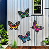 Set of four decorative iron butterflies displayed on a white vertical slat wall.