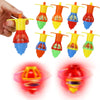A collection of glow-in-the-dark spinning tops in various colors and shapes, some held by a hand.
