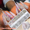 A hand holds an open box of rhinestones, glass gems, and tools for nail art decoration.