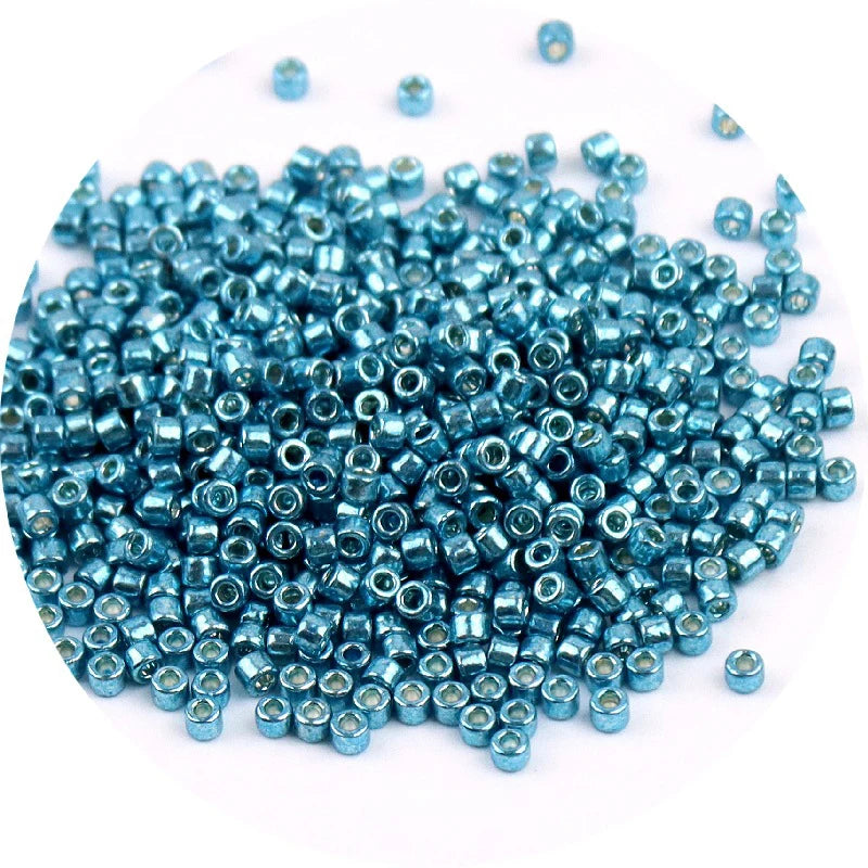 A pile of small, metallic blue glass beads for jewelry making.