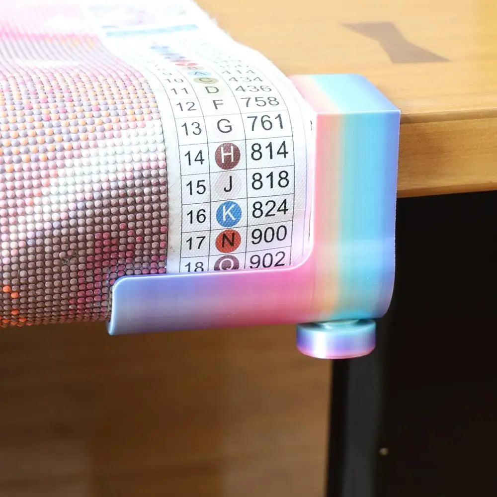 A close-up of an adjustable diamond painting canvas stand with a table clamp and roller, featuring a colorful plastic frame.