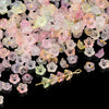 A pile of gradient pink and yellow acrylic bellflower beads for jewelry making