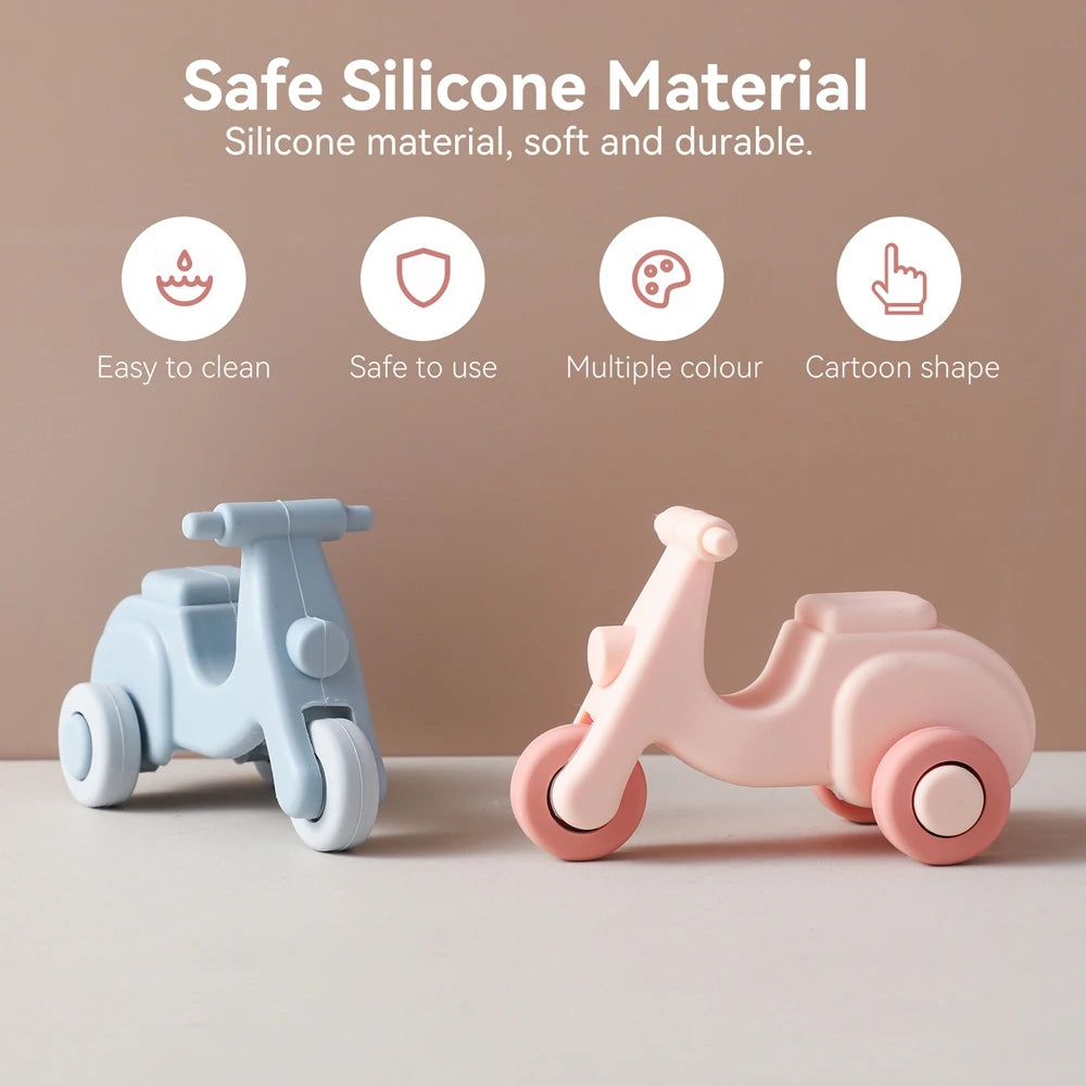 A set of pink and blue silicone toy cars shaped like a unicorn, displayed on a light surface.