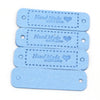 A stack of four light blue leather-style handmade with love tags for crafts and sewing.
