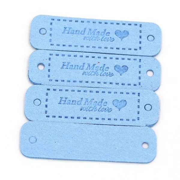 A stack of four light blue leather-style handmade with love tags for crafts and sewing.