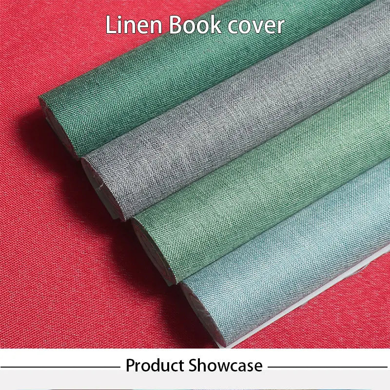 A showcase of various shades of linen book cover fabric rolled out on a red surface.