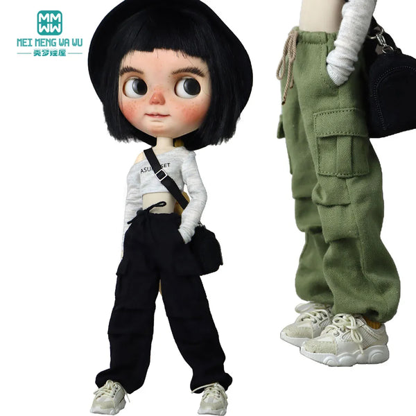 A doll wearing black hair and a white top with black cargo pants and sneakers.