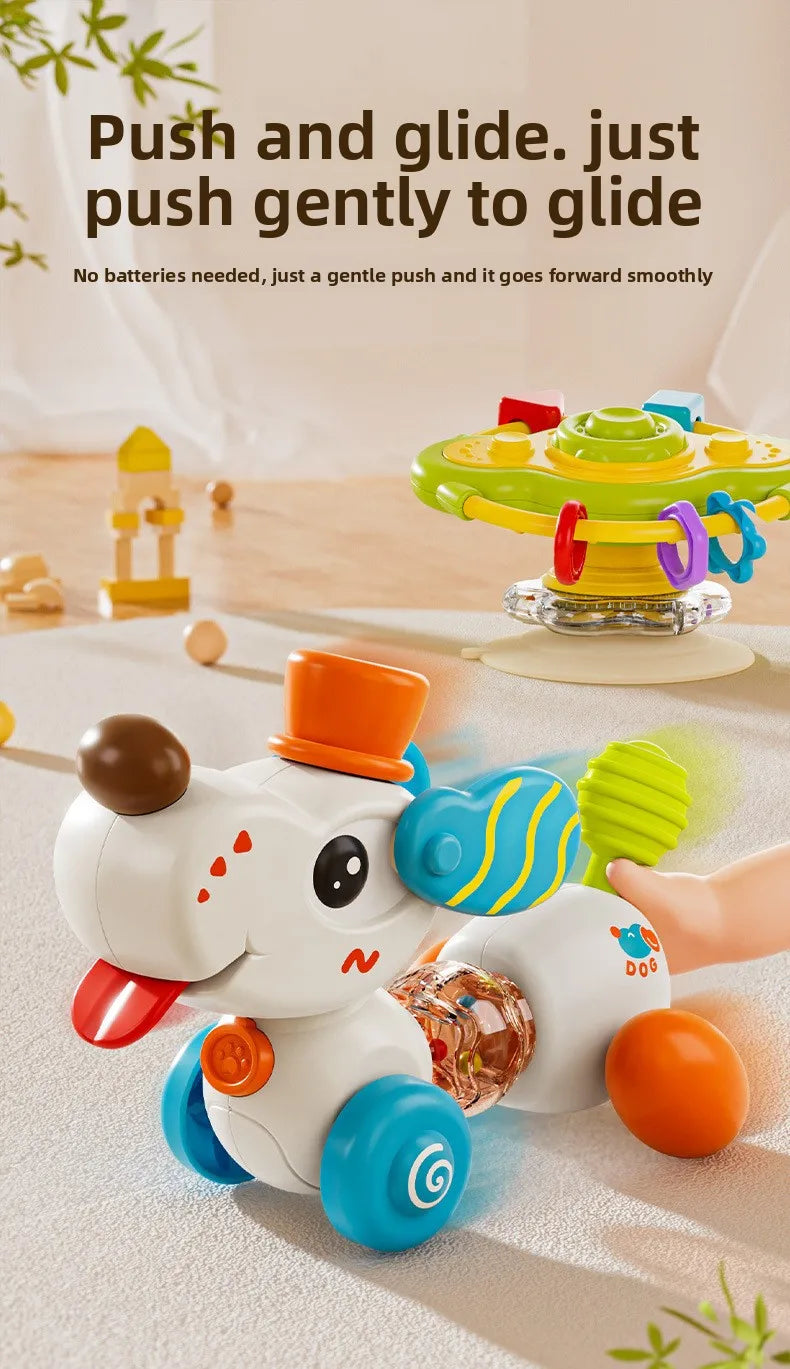 A white cartoon baby rattle toy with blue wheels and orange accents is shown gliding across a light surface.