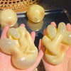 A hand holds a squishy stress relief clay fidget toy shaped like a stylized, wavy blob.