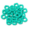 A pile of light turquoise acrylic doughnut spacer beads for jewelry making