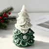 White silicone candle mold shaped like a Christmas tree with green details and white snowflakes.