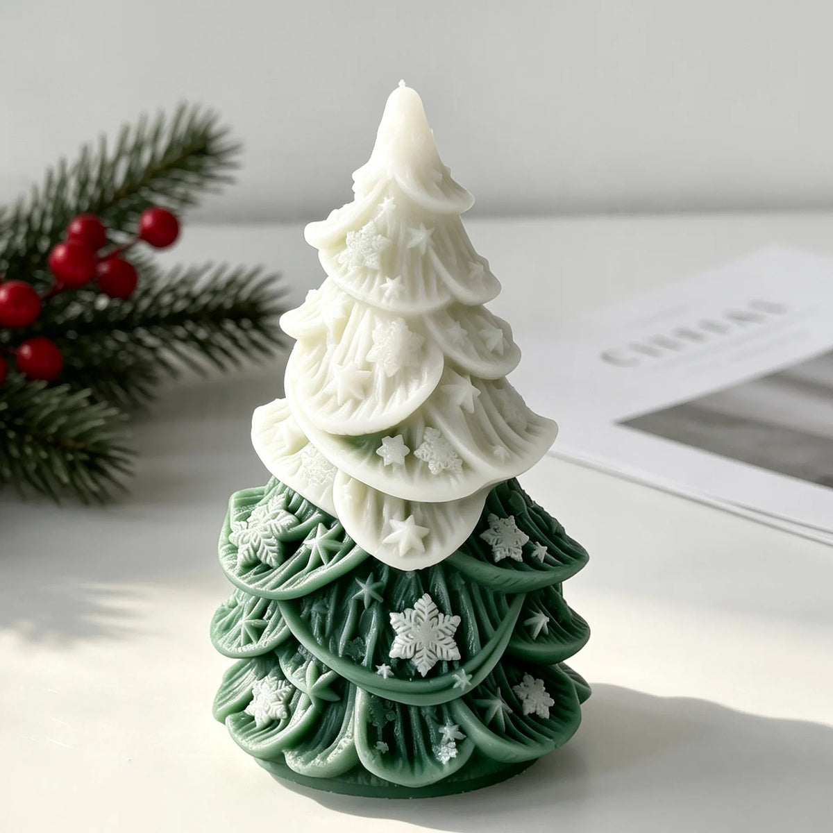 White silicone candle mold shaped like a Christmas tree with green details and white snowflakes.