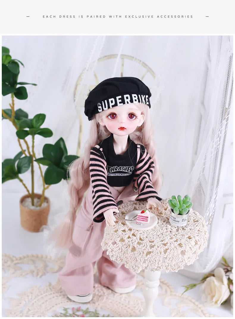 A pink princess doll wearing a black and white striped outfit and a black hat, posed next to a potted plant.