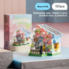 A pink and green micro building block set depicting a flower shop scene with pink flowers and a small house.