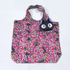 A black and pink floral patterned fabric tote bag with purple handles.