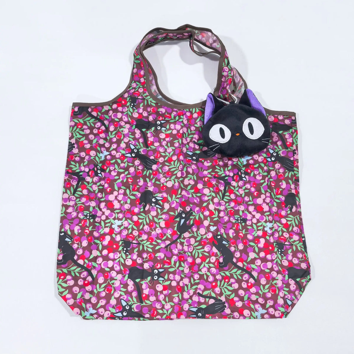 A black and pink floral patterned fabric tote bag with purple handles.