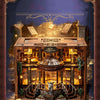 A detailed miniature library model of a wooden book nook with internal lighting and decorative elements.