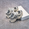A pair of gray and white breathable mesh kids running sneakers resting on a white box.