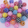 A collection of mixed two-tone striped resin beads in various colors and sizes for jewelry making