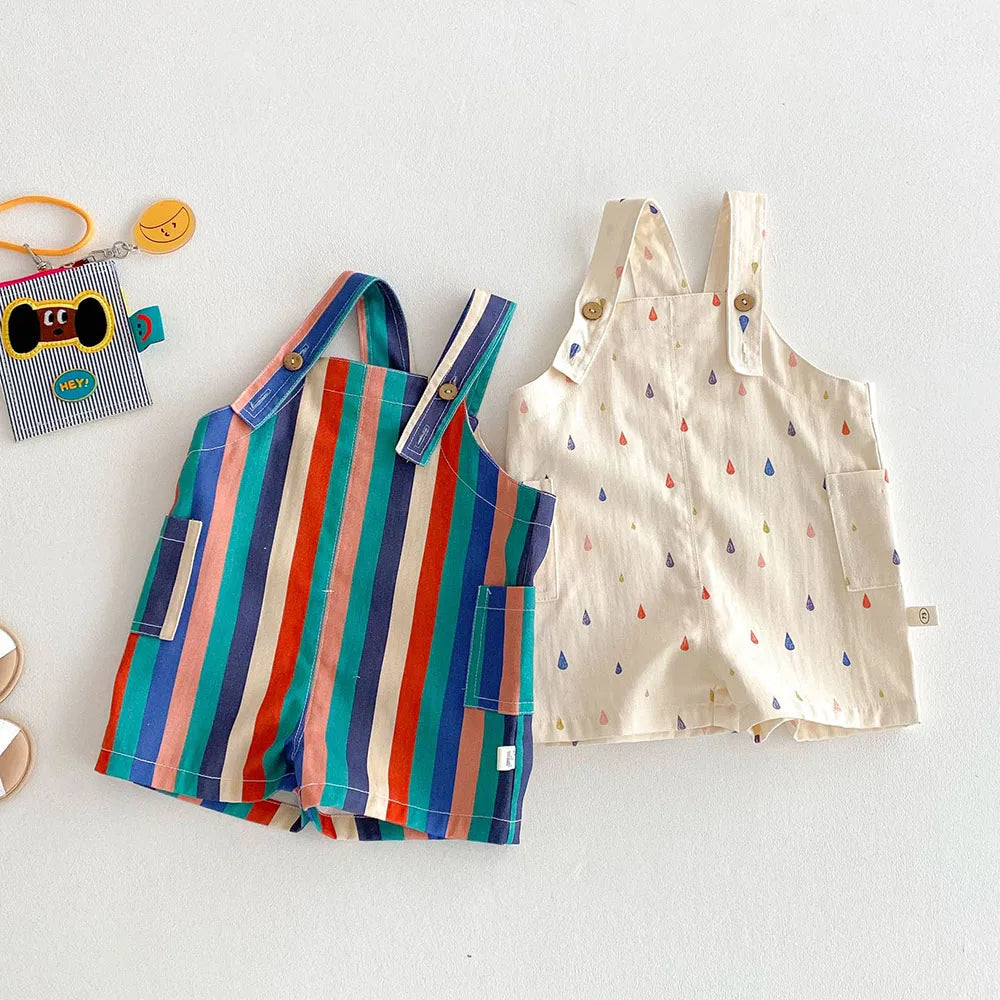 Colorful striped kids overalls with a raindrop print laid out on a white surface.
