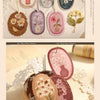 A collection of vintage floral stickers in various shades of pink, green, and purple on white paper.