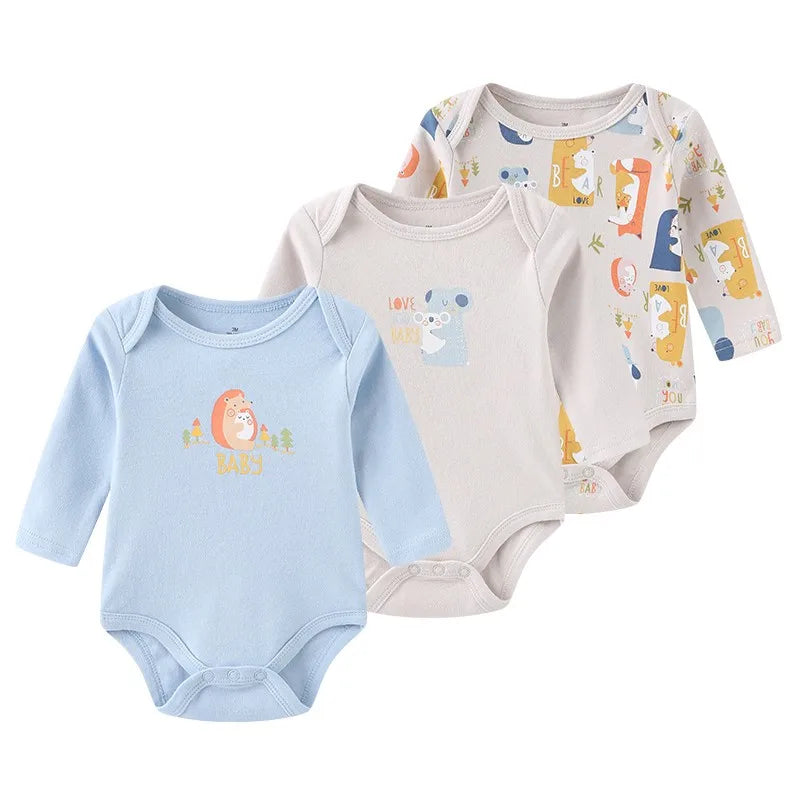 A set of three light blue and beige cotton baby bodysuits with long sleeves featuring cute animal designs.