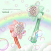 A green sunflower bubble blower toy with pink petals and a rainbow background, showing bubbles being blown.