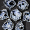 A collection of clear liquid core resin dice set with sharp edges, featuring various numbers and symbols.