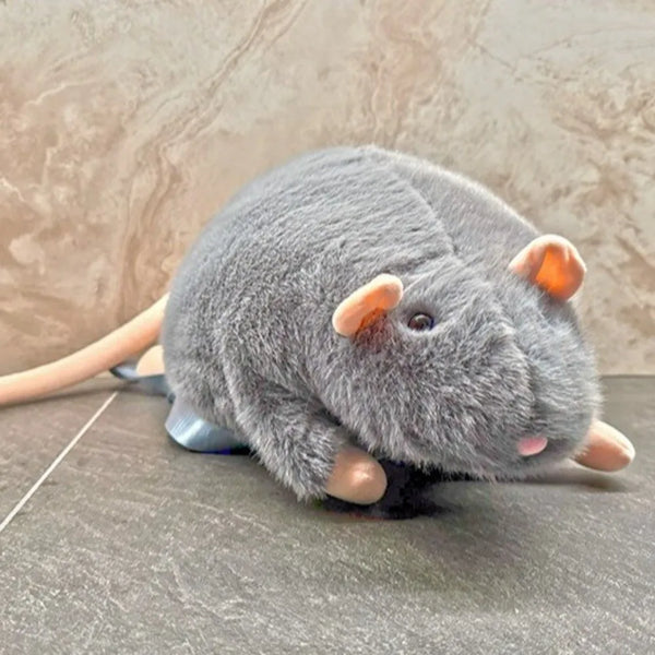 A gray plush toy of a rat with pink ears and a light brown body resting on a dark surface.