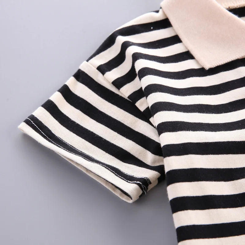 A close-up of a kids' striped outfit set featuring a black and white striped top with a light beige collar.