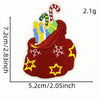 A red iron-on patch shaped like a sack filled with yellow and blue striped candies and green items.